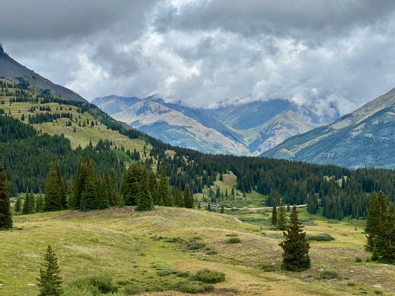 A green valley under low cloud, ridgelines fading into the distance.